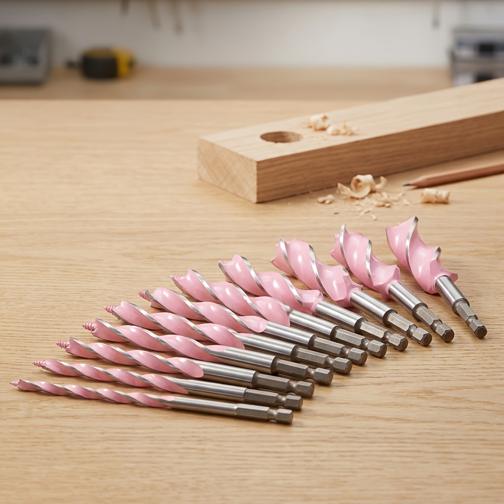 Pink auger drill bit set on a workshop bench